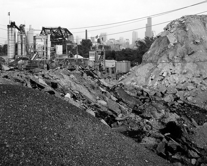 Almost lost in the rubble strewn 
		landscape alongside Fullerton Avenue, a railroad bridge carries trains onto Goose 
		Island